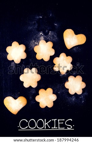 Heart and star shape cookies on the black wooden background from above