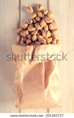 Pistachios in the paper bag from above.Selective focus on the pistachios