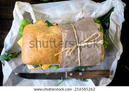 Focaccia sandwich stuffed with ham and cheese on wooden background from above,selective focus