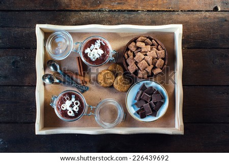 Panna cotta,chocolate,pillows and cookies in the wooden tray from above,selective focus