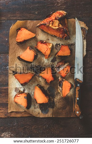 Sliced grilled pumpkin from above on wooden background
