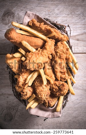 Fried chicken meat and French fries from above in the basket
