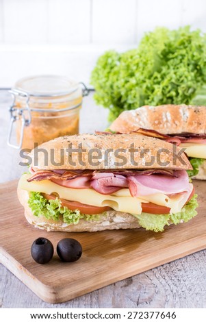 Ciabatta sandwich with bacon and cheese on wooden boarde,selective focus