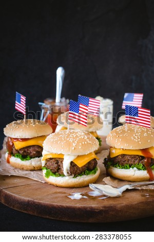 Mini ground beef burgers with American flag on wooden backrgound,selective focus