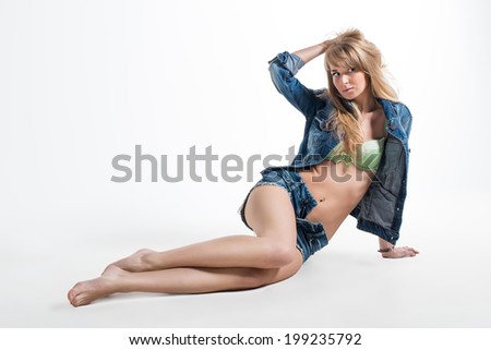Sexy brunette woman beautiful lady in lingerie underwear jeans denim jacket and shorts lying on the floor
