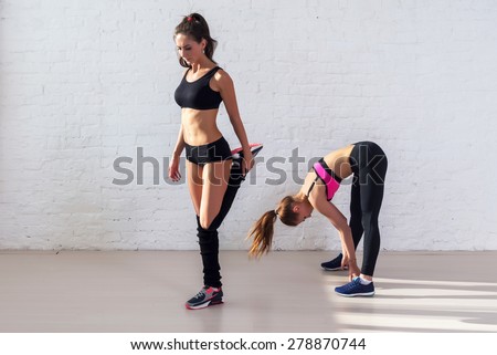 Group of fit women working stretching leg muscles warm up at gym fitness, sport, training and lifestyle concept.