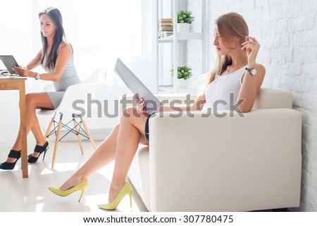 portrait of business woman with folder sitting at office on sofa.