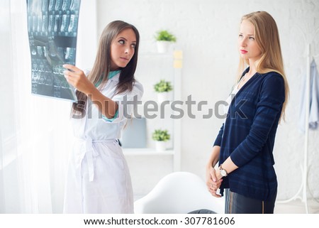 Woman doctor in hospital looking at x-ray film healthcare, roentgen, people and medicine concept