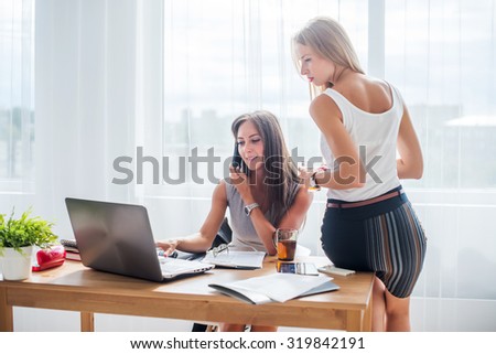 Office coffee break. Businesswoman showing something to colleague on laptop.