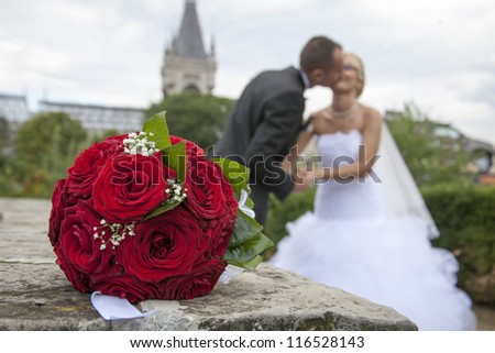 bride and gloom kissing.  beautiful red roses. wedding flowers bouquet. selective focus