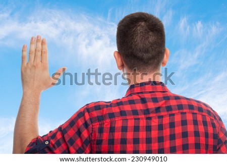 Young man with squares shirt over clouds background. Swearing