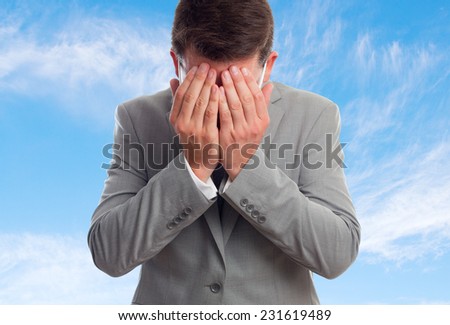 Business man with grey suit over clouds background. Looking sad