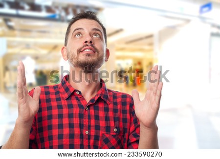 Man with red shirt over shopping center background. Looking happy