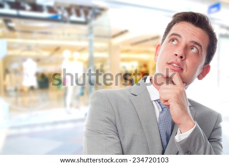 Business man over shopping center background. In a deep thought
