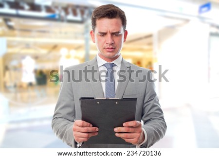 Business man over shopping center background. Reading surprised