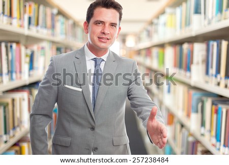 Business man with grey suit. He is doing the checking hands gesture. Over library background