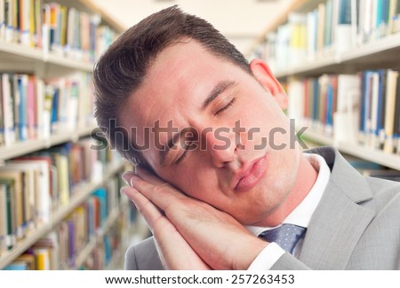 Business man with grey suit. He is looking tired. Over library background