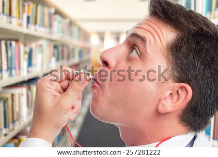 Man with white shirt using a whistle. Over library background