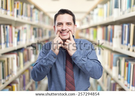 Man wearing a blue shirt and red tie. He looks happy. Over library background