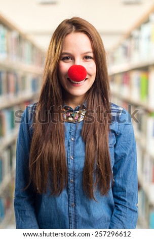 Trendy young woman with a red nose smiling. Over library background
