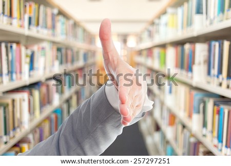 Business man with grey suit hand. It is doing the checking hands gesture. Over library background