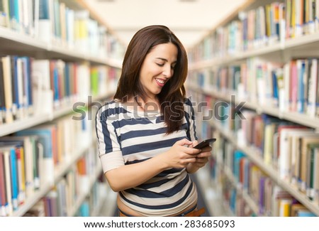 Smiling woman using a smart phone. Over library background