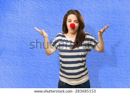 Confused woman with clown nose. Over blue background