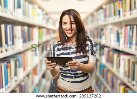 Smiling woman using a tablet. Over library background
