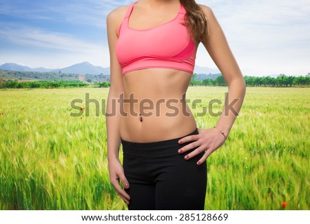 Young woman wearing gym clothes. Her belly closeup