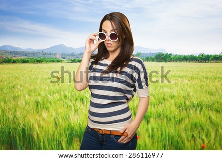 Sexy woman with white sunglasses. Over meadow background