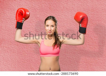 Young woman wearing gym clothes. She looks serious with her boxing gloves. Over red background