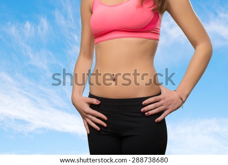 Young woman slim belly closeup. Over clouds background