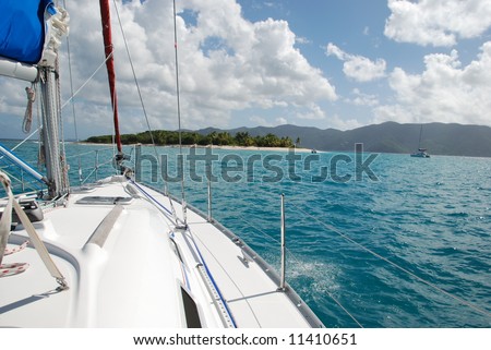 Sailboat approaching desert island.  British Virgin Islands.