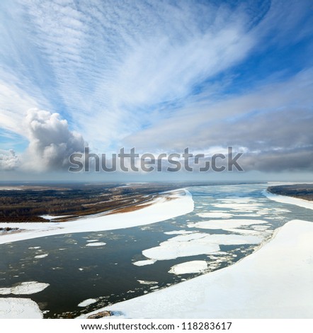 Aerial view of the great river with floating ice floes during the spring day. Drifting of ice. Driving of ice. Ice floe.