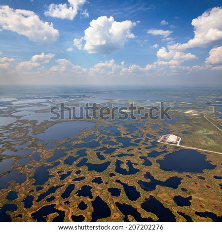 Aerial view of oilfield on impassable swamp area. - stock photo