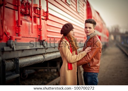 young couple in love near the red train