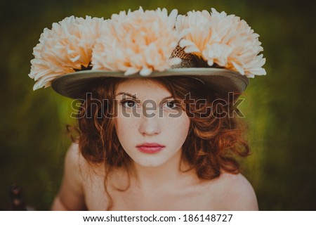 Portrait of a young redhead woman dressed as Alice in Wonderland.