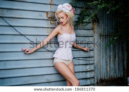 Portrait of sexy woman in white underwear on a  wall