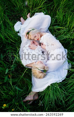 two sisters twins lying on green grass