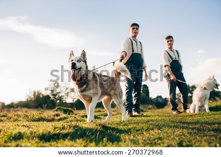 Twins take a walk with the dogs Huskies