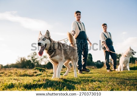Twins take a walk with the dogs Huskies