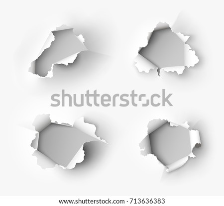 Holes torn in paper on white background