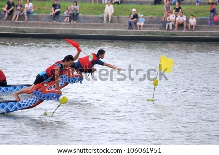 YILAN TAIWAN - JUNE 24: red team\'s flag fetcher first snatched the flag at the end point.   The Dragon Boat Festival  on the Dongshan River on June 24, 2012 in Yilan