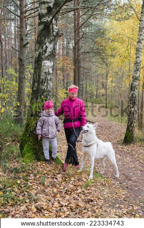 Granny with her granddaughter and a dog walk in autumn Park