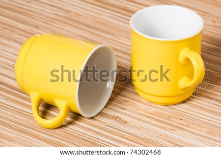 Two yellow mugs on a table, a close up