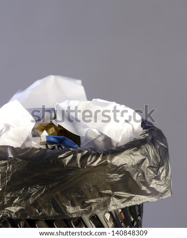 Close up photo of a trash can full of papers