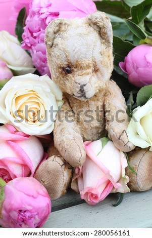 Vintage teddy bear with Pink and cream flowers, roses and peonies, on wooden bench with bright pink wood back ground, shabby chic floral arrangement , romantic valentine or wedding image