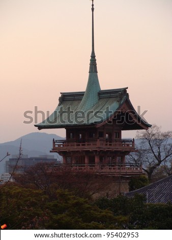 Japanese landscape of pagoda and hills at dusk in Kyoto, Japan, a traditional Japanese building or temple  with a green roof and carved wood balconies