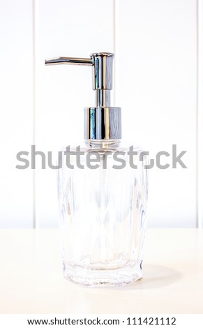 Glass pump soap bottle without label on white background