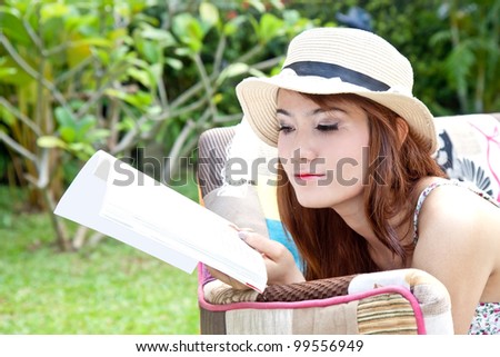Beautiful asian woman reading her book in the garden